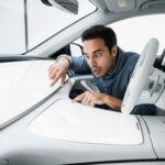 AI satire illustration: Ferrari Driver Crashes While Searching For Brake Pedal Gesture On Smooth Dashboard